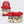 A set of four Kit Sch satin scrunchies displayed on a light gray background, with the retail packaging card standing behind them. The scrunchies include a large red satin scrunchie, a green and red plaid satin scrunchie, a cream satin scrunchie, and a matching plaid and satin combination.