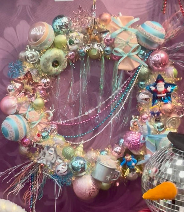 Decorative wreath with colorful ornaments and tinsel on a purple background Rudolph the Red Nosed Reindeer themed handmade wreath 